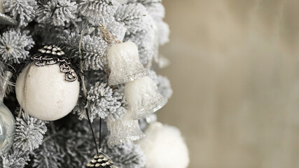 Isolated gray-white Christmas tree with toys and garlands on concrete background