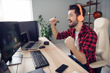 Profile side view of nice trendy cheerful ecstatic bearded guy playing video game competition...