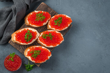 Sandwiches with red caviar on a dark blue background.