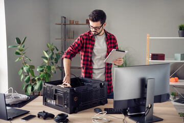 Portrait of attractive skilled qualified trendy guy upgrading processor hardware at office...