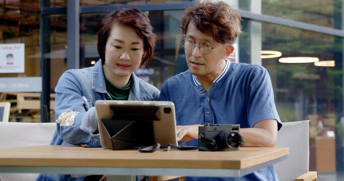 Asian couple and family are using credit card to shopping online on their laptop using free wifi high speed internet 5G in coffee shop or place. activity weekend vacation of traveling together happy.