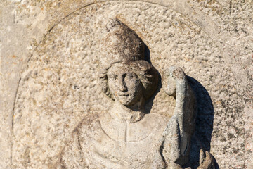 Old stone monument on the grave in the cemetery in autumn