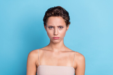 Photo of unhappy upset young woman dressed beige top knowing bad news isolated blue color background