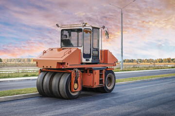 Obraz premium Heavy-duty vibratory roller for asphalt paving. Road construction. Construction of roads and urban transport communications. Heavy machinery.