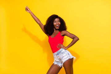 Portrait of attractive cheerful girl having fun rest dancing free time weekend isolated over bright yellow color background
