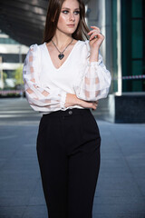 Fototapeta premium Young business woman on the street of a modern city in black and white