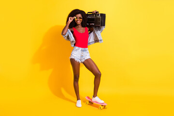 Full length body size view of attractive cheerful girl carrying player sound rhythm isolated over bright yellow color background