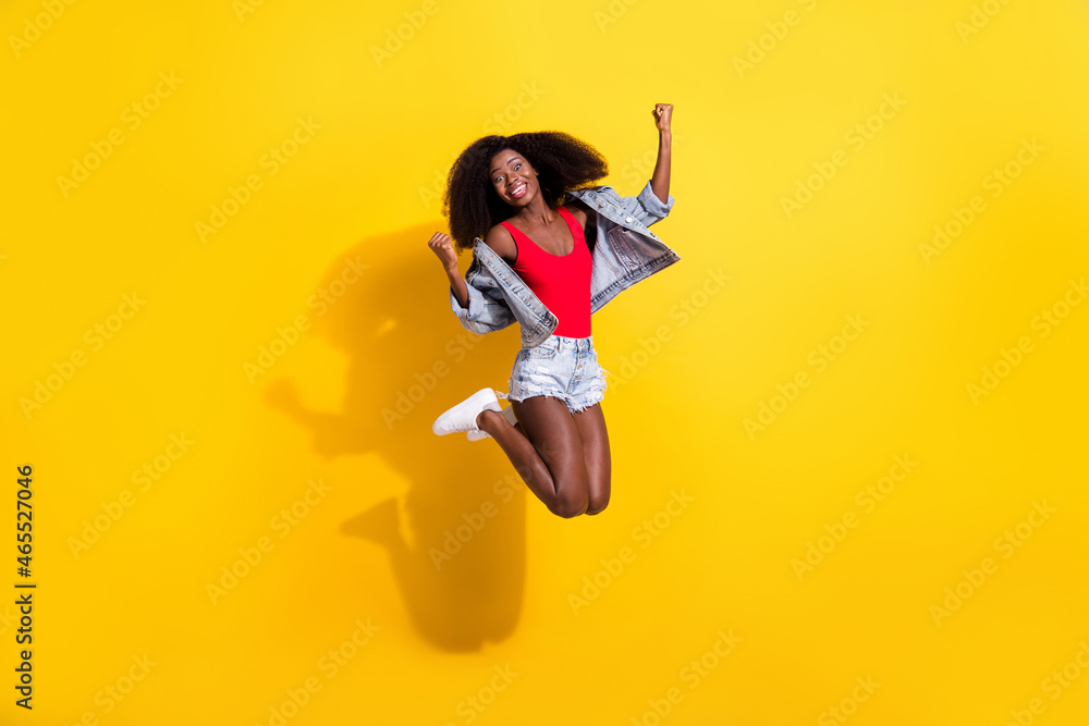 Poster Full length body size photo of girl jumping high gesturing like winner happy overjoyed isolated vivid yellow color background