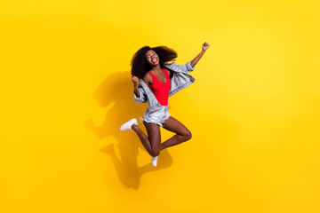 Plakat Full length body size photo of girl jumping high gesturing like winner stylish outfit isolated on bright yellow color background
