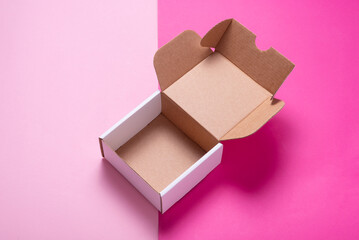 Simple white cardboard box on color background, opened, empty inside