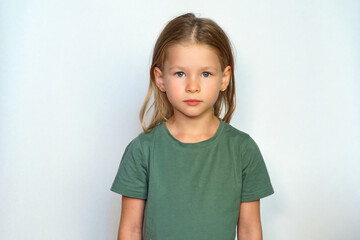 serious child looks at the camera. place for text. Portrait of a girl on a white background....