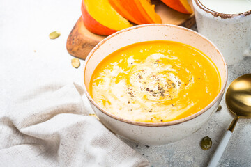 Pumpkin soup puree with cream in the craft bowl. Close up.