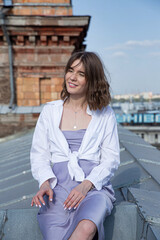 Happy young european woman on the roof with city view behind