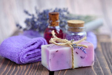 Obraz na płótnie Canvas Lavender spa products on wooden table. Body care products with lavender: soap, oil, salt and dried lavender flowers. Selective focus.