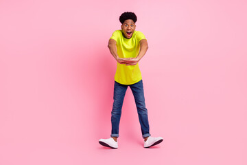 Fototapeta premium Full length photo of young excited afro guy happy positive smile have fun isolated over pink color background