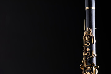 Naklejka premium Part of a clarinet with gold plated keys on a black background. A woodwind instrument common to classical music.