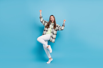Full length photo of cheerful young woman winner good mood luck celebrate isolated on blue color...