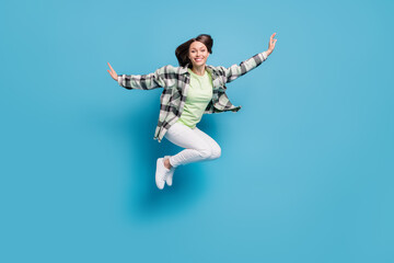 Fototapeta na wymiar Full body profile side photo of young cheerful girl happy positive smile fly air jump isolated over blue color background