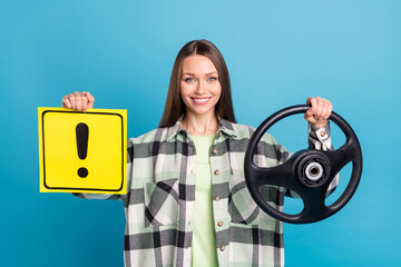 Photo of young girl happy positive smile hold steering-wheel attention sign novice driver isolated over blue color background