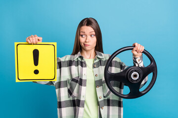 Photo of young girl look warning sign unexperienced driver hold steering-wheel isolated over blue color background
