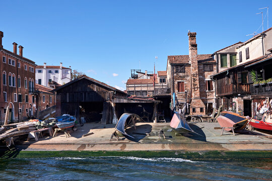 Venice, panoramic image of empty Squero di San Trovaso boatyard in Venice. Landmark boat yard building traditional wooden gondolas. Several boats are waiting to be fixed, repaired on the shore.