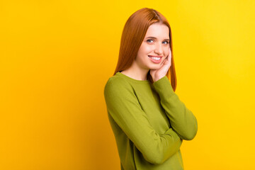 Photo portrait red haired woman in green sweater smiling touching cheek isolated vivid yellow color background copyspace