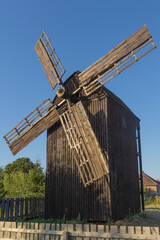 Fototapeta na wymiar Wooden mill on a background of blue sky