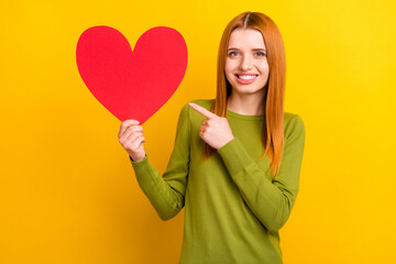 Photo of pretty red hairdo millennial lady point heart wear green sweater isolated on yellow color background