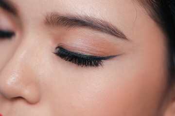 Close-up eyes closed with makeup with brown eyebrows and black lashes