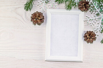 Festive New Year and Christmas background with spruce branches, snowflakes and cones. White wooden background with copy space, wooden frame, mock up