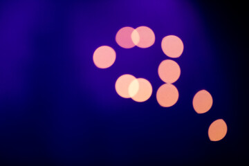 Eleven yellow round bokeh elements on a purple background