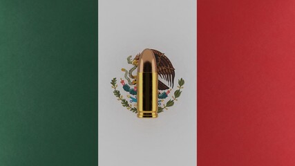 Top down view of a 9mm bullet in the center and on top of the flag of Mexico