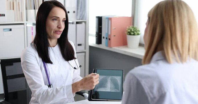Doctor showing digital tablet to patient with CT scan of lungs 4k movie