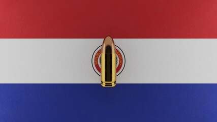 Top down view of a 9mm bullet in the center and on top of the flag of Paraguay