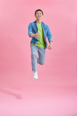 Handsome man jumping over pink