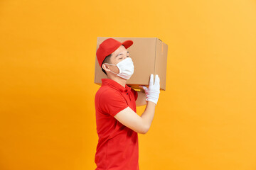 Courier in a face mask with a box in his hands.