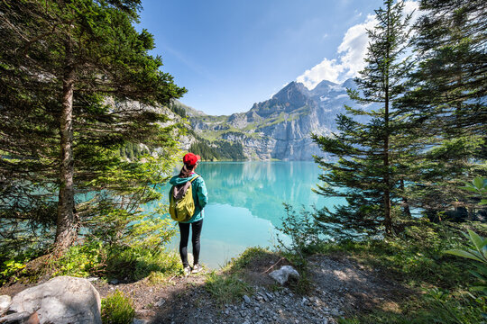 Young woman standing in front of Oeschinen Lake near Kandersteg, Bernese Oberland, Switzerland