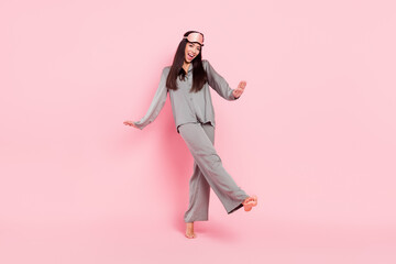 Full length photo of charming shiny lady sleepwear mask dancing walking smiling isolated pink color background