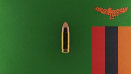 Top down view of a 9mm bullet in the center and on top of the flag of Zambia