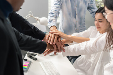 Fototapeta premium Hands of different nationalities, different skin colors, placed on top of each other, one on top of the other, intertwined, an agreement, a close-knit team, working together, a bet, all for one