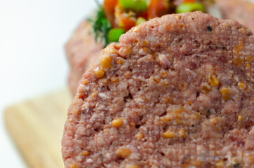 Raw beef burgers blended with caramelised red onion and tangy red Leicester cheese prepared for grilling