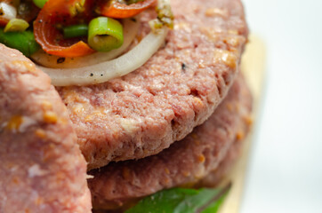 Raw beef burgers blended with caramelised red onion and tangy red Leicester cheese prepared for grilling