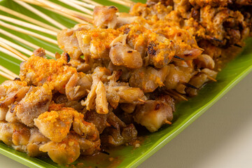Sate taichan or Taichan satay with grilled chicken skin  is a variation of chicken satay grilled and served without peanut or ketchup served with chili sauce. Selective focus , blurry. 