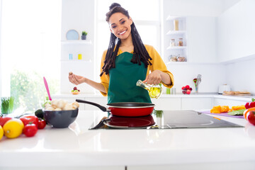 Photo of pretty adorable dark skin lady wear yellow shirt cooking using oil frying pan indoors you...