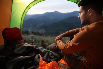 Fototapeta premium Man inside of camping tent in mountains