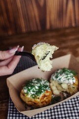 Close-up of potato tortilla prepared in a fast food restaurant. Brazil national cuisine. Food in a cardboard box. Takeout food. Round buns with potatoes and cheese.
