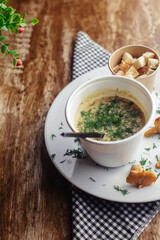 Close-up of soup in a glass. Takeaway food in disposable dishes. A paper cup with a hodgepodge, mushroom soup and croutons. The concept of fast food in a cafe.