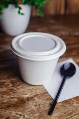 Close-up of soup in a glass. Takeaway food in disposable dishes. A paper cup with a hodgepodge, mushroom soup and croutons. The concept of fast food in a cafe.