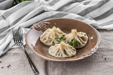 Georgian dumplings Khinkali with meat on brown plate on the table