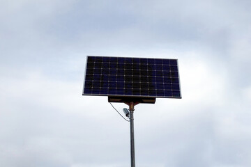 Solar panels on a pillar against the backdrop of a cloudy sky. Green energy concept